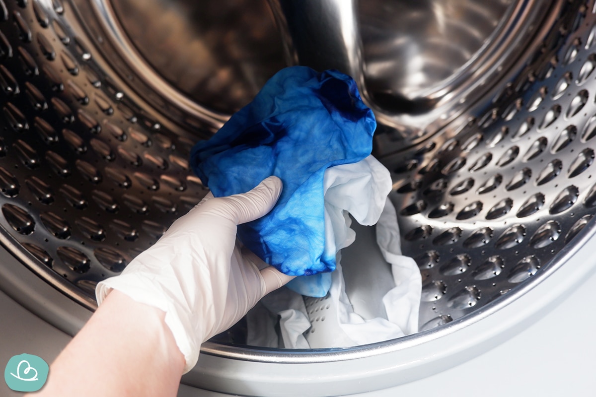 Blauen Batikstoff in einen Waschmaschine legen.