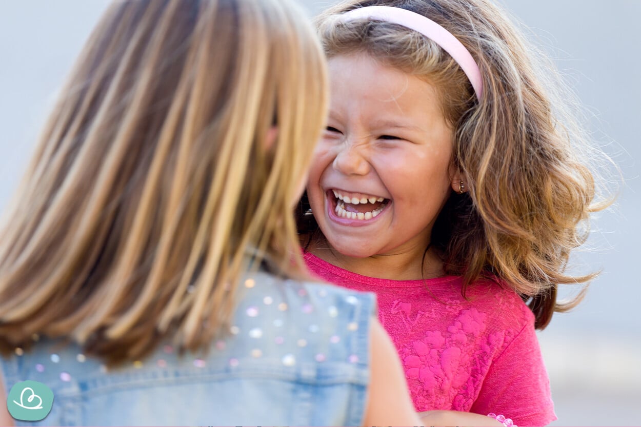 Kinder erzählen sich Zungenbrecher und lachen zusammen.