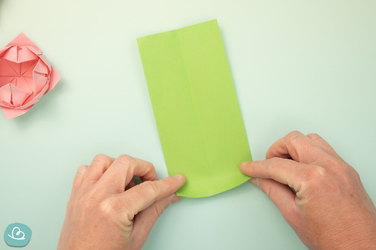 Ecken eines Papierstreifens zur Mitte falten