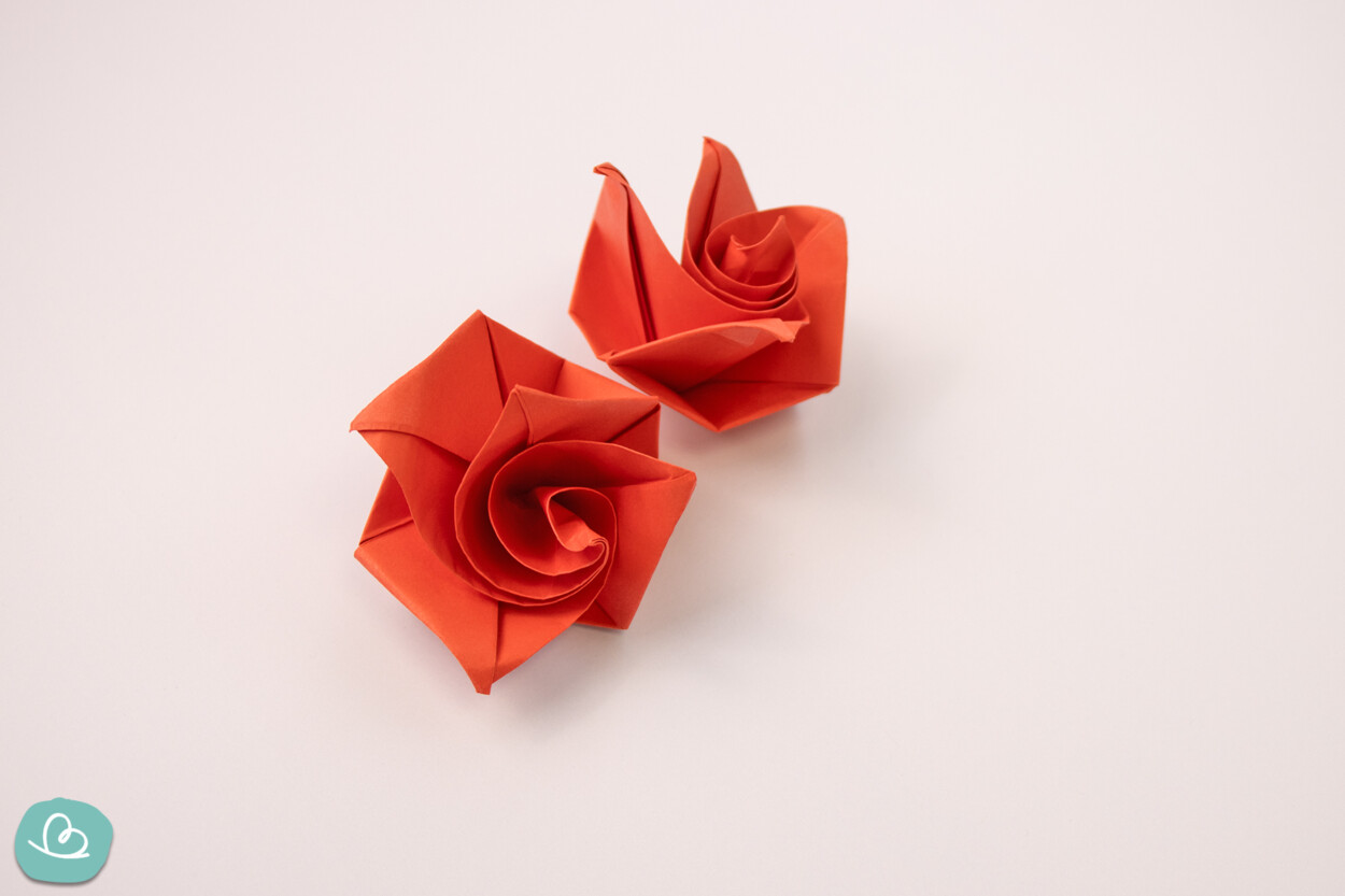 Gefaltete rote Origami Rose auf weißem Hintergrund