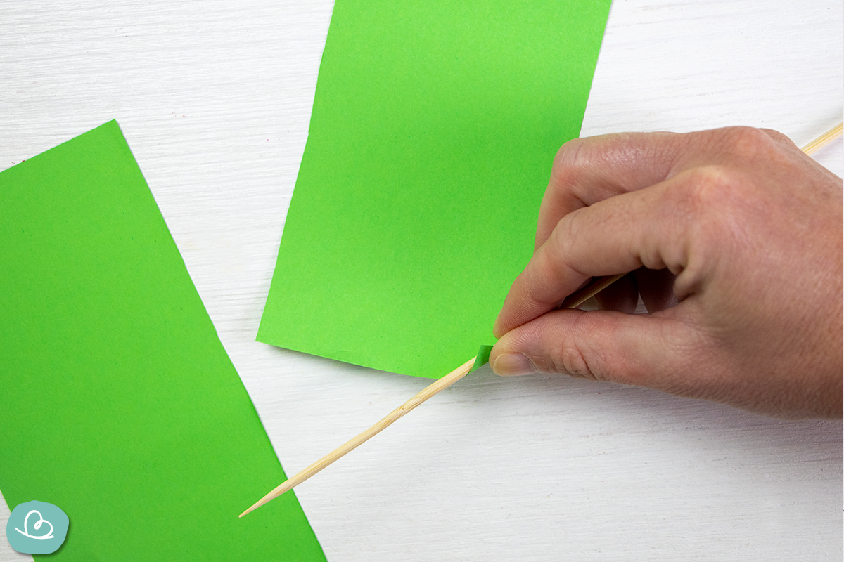 Papier auf Holzspieß aufrollen