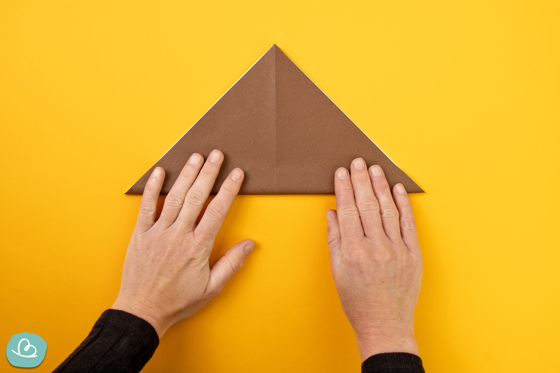 Origami Papier zu einem Dreieck falten.
