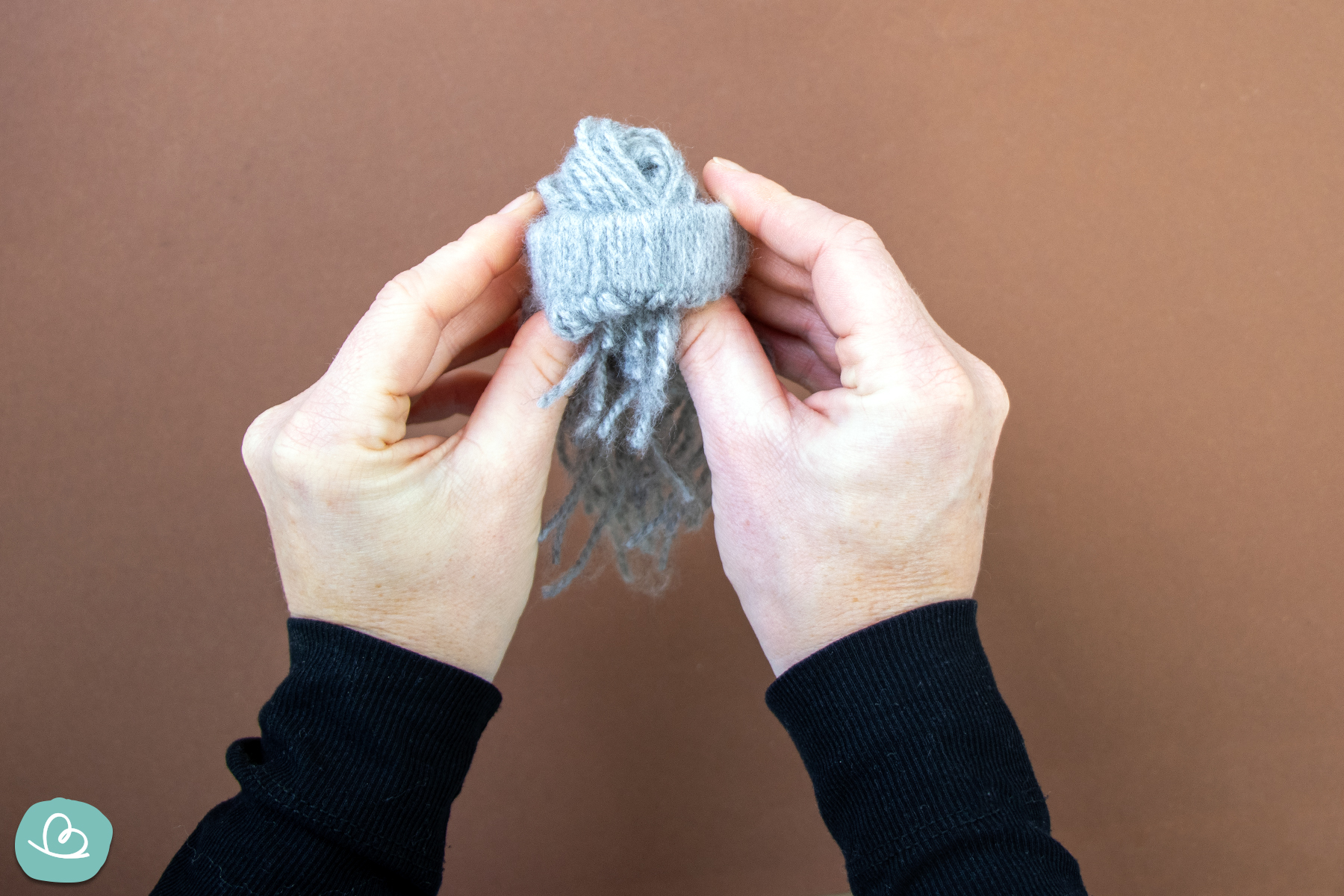 Wollfäden am Pappring wenden