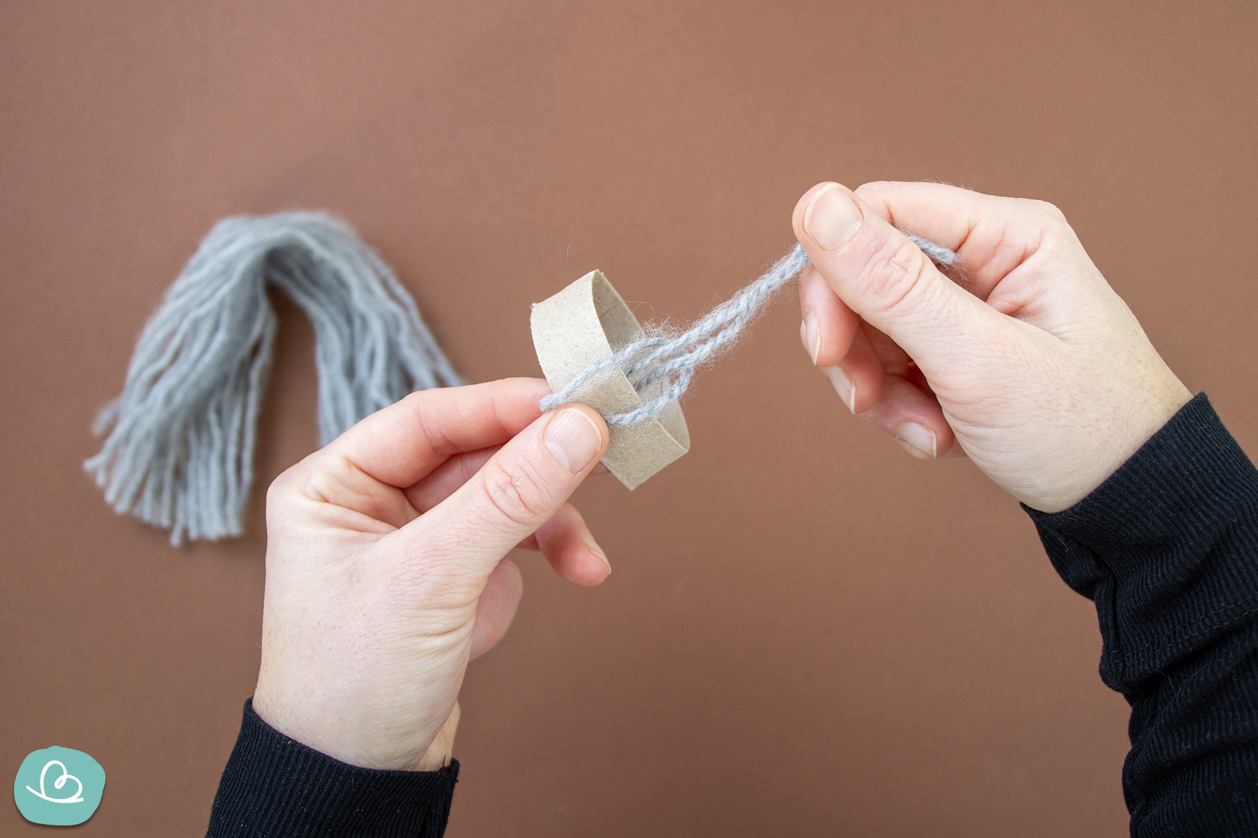 Wollfäden anbinden und anknüpfen an Pappstreifen