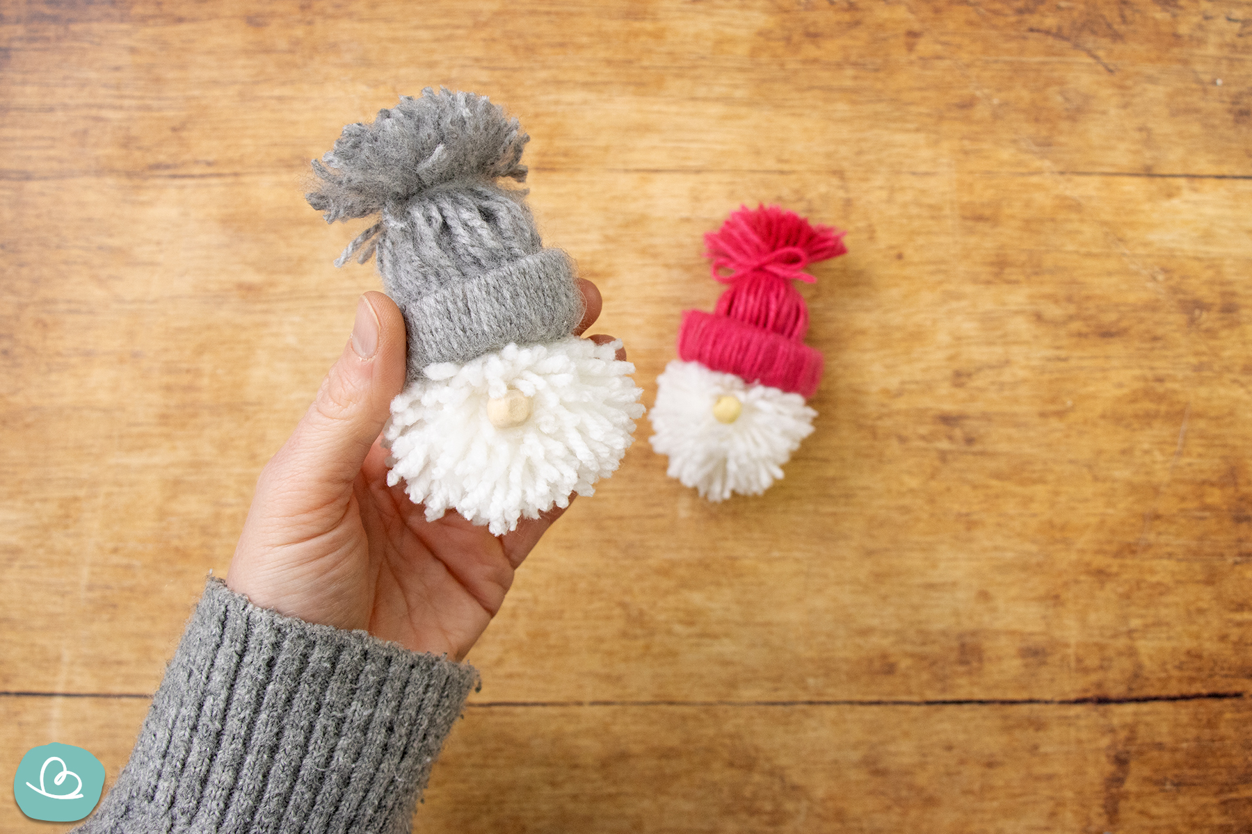 Kleiner Weihnachtswichtel aus Wolle in den Händen haltend