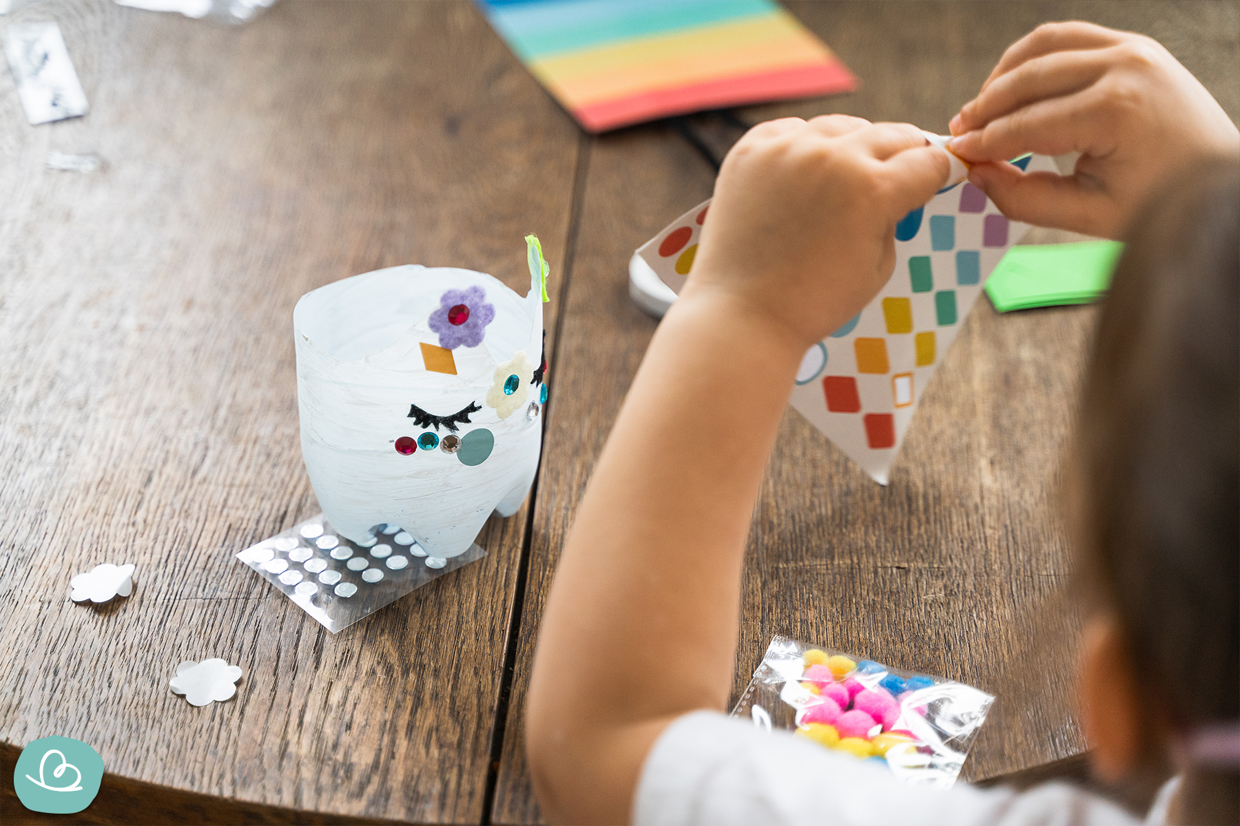 Kind bastelt mit Aufklebern uns bunten Stickern