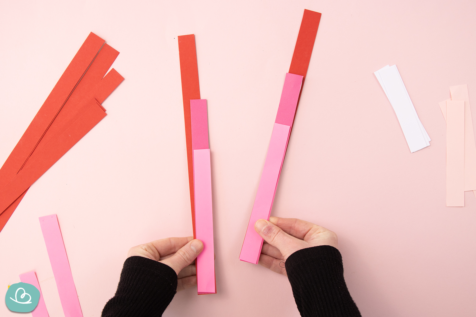 Papierstreifen in unterschiedlichen Größen den Händen haltend